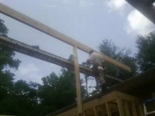 Carpenter setting a ridge beam over a new addition frame — Ice Dam Removal by Roofing Brothers in Hiram