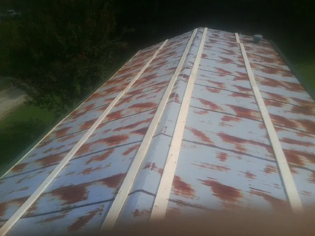 Rusted metal roof panels with new wood purlins before replacement — Storm Damage Roof Repair in Hiram by Roofing Brothers